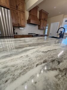 marble kitchen island with dark wood cabinets in the background